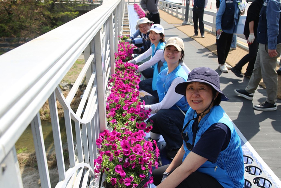 금토천변에 꽃 식재하는 이일화 배우와 임직원들